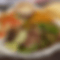 A couple of thinly sliced skirt steak sauteed and grilled with onions, green bell peppers, and tomato. garnished with lettuce, sour cream, guacamole, tomato, and a lime wedge. 